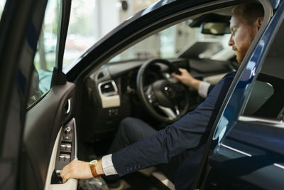 Businessman testing car in car dealership