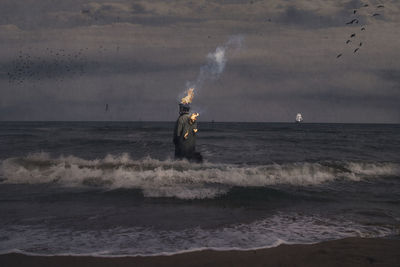 Man standing in sea against sky