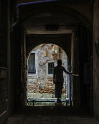 Rear view of man walking in corridor