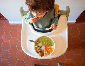 High angle view of woman holding food on table