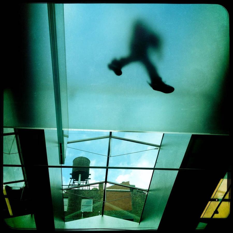 LOW ANGLE VIEW OF SILHOUETTE MAN STANDING ON GLASS