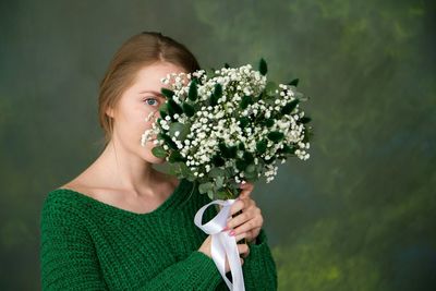 Portrait of beautiful woman holding flower bouquet