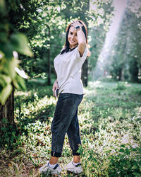 Portrait of mid adult woman walking on grassy land in forest