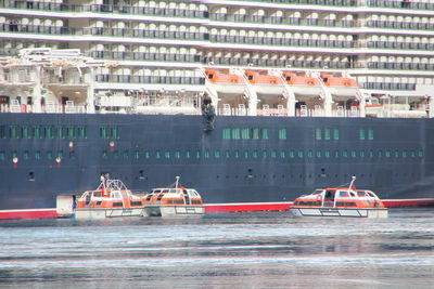 Boats in sea against buildings in city