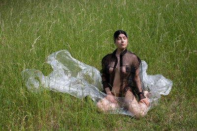 Young woman sitting on grassy field