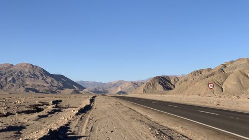 Scenic view of desert against clear blue sky