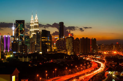 Light trails on two lane highway leading towards petronas tower