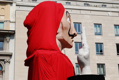 Rear view of woman standing against building