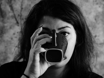 Close-up of young woman photographing through camera