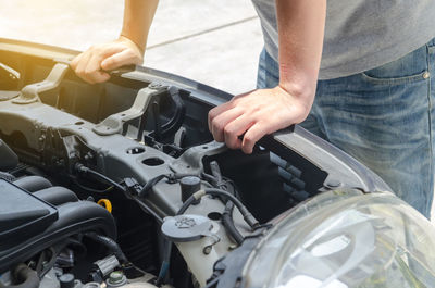 Cropped image of person repairing car