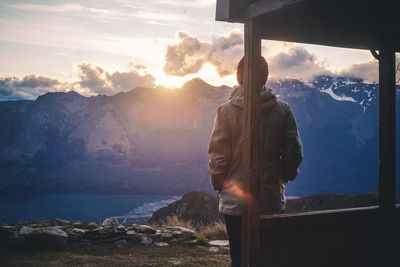 Man standing on rock against sky