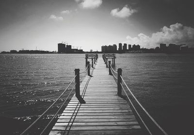 Boardwalk by sea against clear sky