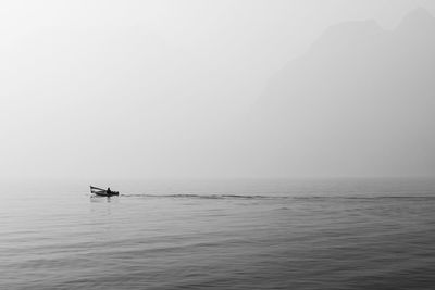 Boat sailing in sea against clear sky