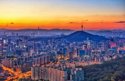 High angle view of city lit up at sunset