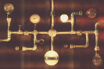 Close-up of illuminated light bulb hanging against sky