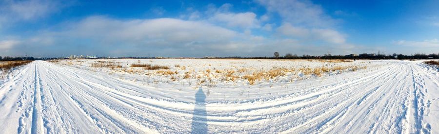 Panoramic view of snow covered land against sky