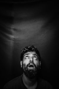 Portrait of young man against black background