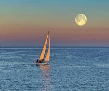 Beautiful sunset sailboat cruise under full moon in santa cruz bay