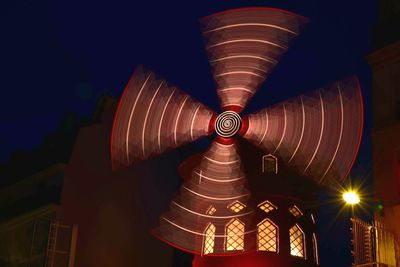 Blurred motion of illuminated traditional windmill at night