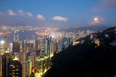 Illuminated buildings in city against sky at night