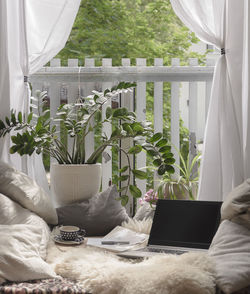 Close-up of laptop amidst cushions at home