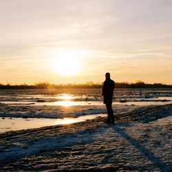 Silhouette of people standing on snow covered landscape