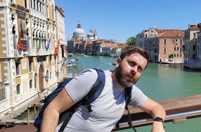 Man in canal amidst buildings in city