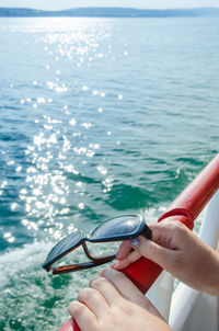 Low section of woman holding sea against sky