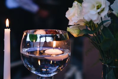 Close-up of lit candles on glass table