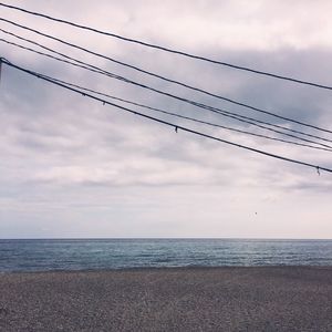 Power lines against cloudy sky