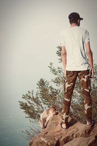 Man with dog standing at riverbank