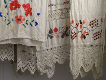 Close-up of clothes hanging against white curtain