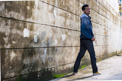 Portrait of man standing by wall