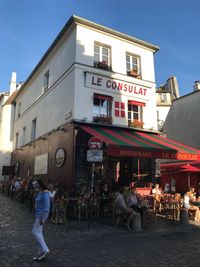 People in restaurant against buildings in city