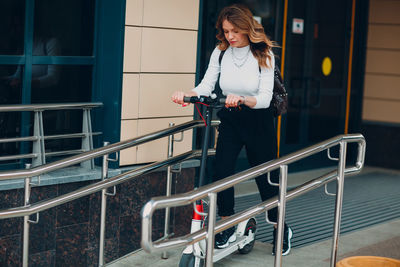 Woman riding push scooter