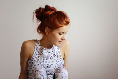 Young woman looking away against white background