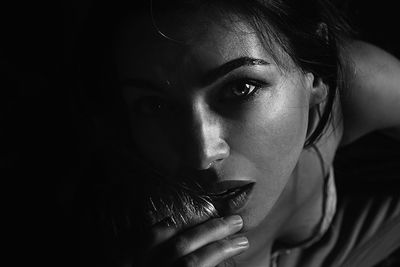 High angle portrait of beautiful woman sitting in darkroom