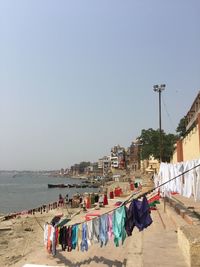 Clothes drying on beach against clear sky