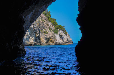 Rock formation in sea against sky