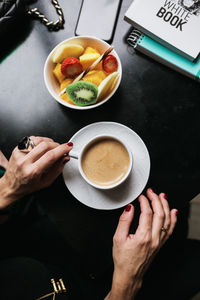 High angle view of hand holding coffee cup