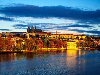 Bridge over river by buildings against sky in city