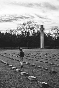 Rear view of man on field against sky