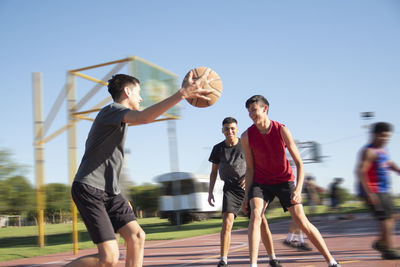 Portrait of young teenage boys playing basketball