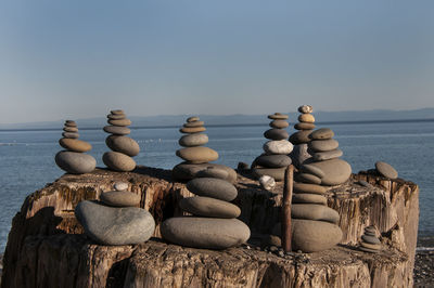 Stack of rocks on beach against clear sky