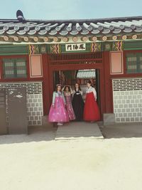 Rear view of women standing outside building