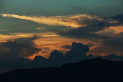 Low angle view of silhouette mountains against dramatic sky