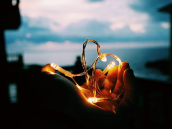 Close-up of hands at sunset