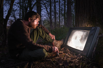 Watching television in forest.