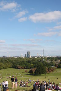 Group of people relaxing in park against sky