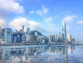 Reflection of buildings in city against sky